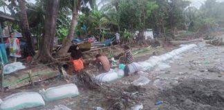 Warga Kampong Bakara Desa Pa'jukukang, Kecamatan Pa'jukukang yang mukim di pesisir pantai bergotong-royong membangun tanggul pasir penahan ombak